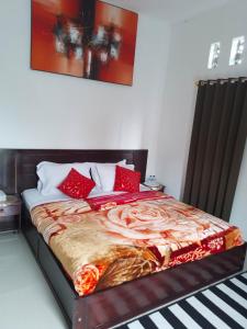 a bed with red pillows on it in a room at D'La CoCo Villa in Bangli