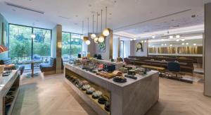 a restaurant with a buffet in the middle of a room at Manxin Hotel Guangzhou Baiyun Airport Branch in Guangzhou