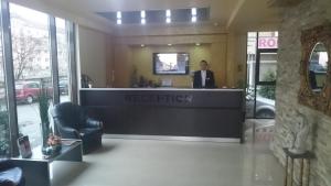 a man standing at a reception desk in a lobby at Hotel Angellis in Timişoara