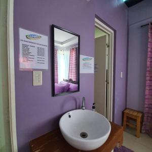 a bathroom with a white sink and a mirror at Bahai Jujai Resort in Baler