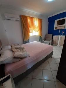 Un dormitorio con una cama grande y una ventana en Estrela do mar 3 dormt, en Bombinhas
