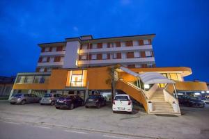 un grand bâtiment avec des voitures garées dans un parking dans l'établissement Hotel Toscana, à Figline Valdarno