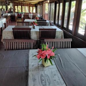 a restaurant with tables and chairs with flowers on them at Boraha Village Ecolodge in Sainte Marie