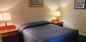 a hotel room with a bed and two lamps at Nanango Antler Motel in Nanango