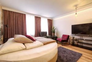 a hotel room with a bed and a television at Kavenija apartmaji - Free Parking in Maribor