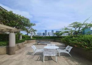 una mesa y sillas en un patio con vistas al perfil urbano en BU Place Hotel en Bangkok