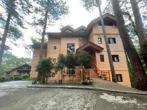 a house in the woods with a driveway at 2BR- 4th Floor Camp John hay For Rent in Baguio