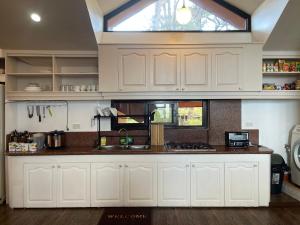 a kitchen with white cabinets and a window at 2BR- 4th Floor Camp John hay For Rent in Baguio
