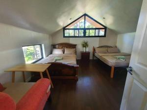 a large room with two beds and a window at 2BR- 4th Floor Camp John hay For Rent in Baguio