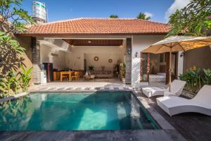 a swimming pool in front of a house at [Seminyak central] private 3 bedrooms villa with swimming pool in Seminyak