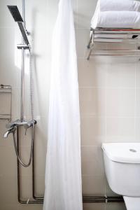 a bathroom with a shower curtain and a sink at The Assembly Place at Stevens, Service Residences in Singapore