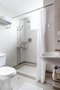 a bathroom with a shower and a toilet and a sink at The Assembly Place at Stevens, Service Residences in Singapore