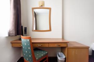 a desk with a mirror and a chair in a room at The Assembly Place at Stevens, Service Residences in Singapore