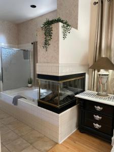 a bathroom with a bath tub with a fireplace at KMEL HOME in Bakersfield