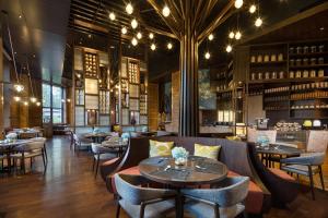 um restaurante com mesas e cadeiras e um bar em Crowne Plaza Resort Changbaishan Hot Spring, an IHG Hotel em Antu