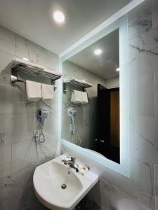uma casa de banho com um lavatório e um espelho em Hotel Key em Queens