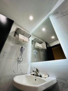 uma casa de banho com um lavatório e um espelho em Hotel Key em Queens
