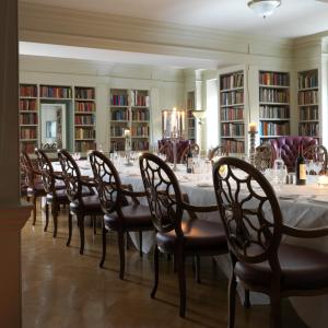 uma longa sala de jantar com uma longa mesa e cadeiras em The Bloomsbury Hotel em Londres