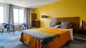 a bedroom with a large bed and a yellow wall at Kêr L - Breizh & Breakfast in Cancale
