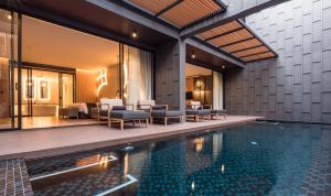 een zwembad in een villa met tafels en stoelen bij The Yana Villas Hua Hin in Hua Hin