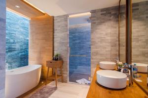 a bathroom with two sinks and a tub and a shower at The Yana Villas Hua Hin in Hua Hin