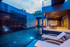a swimming pool with chairs and a house at The Yana Villas Hua Hin in Hua Hin