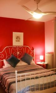 a bedroom with red walls and a bed with two pillows at Artemis Apartment,Beach two-bedroom in Artemida