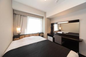 1 dormitorio con cama, espejo y lavamanos en APA Hotel Namba Shinsaibashi Higashi, en Osaka
