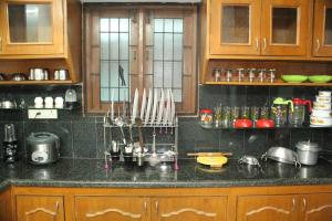 a kitchen with wooden cabinets and a black counter top at FriendlyStay at Madanandapuram in Chennai