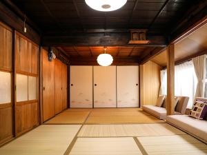 een lege kamer met houten lambrisering en een plafond bij Kokoyui Guest House in Nachikatsuura