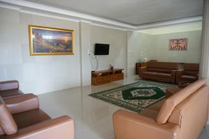 a living room with a couch and a tv at Griya Kayana Inn and Villas in Bogor