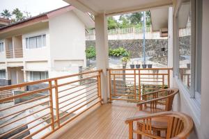 einen Balkon mit 2 Stühlen und Blick auf ein Gebäude in der Unterkunft Griya Kayana Inn and Villas in Bogor