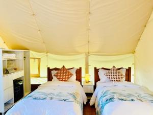1 Schlafzimmer mit 2 Betten in einem Zelt in der Unterkunft 見晴花園山莊Sunshine Villa in Renai