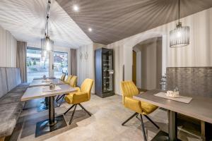a dining room with a table and yellow chairs at Appartements Perberschlager in Oetz