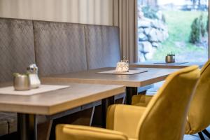 une salle à manger avec deux tables et des chaises jaunes dans l'établissement Appartements Perberschlager, à Oetz