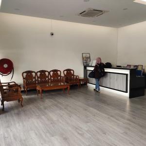 a woman standing in a room with chairs at Hotel K T Mutiara in Kuala Terengganu