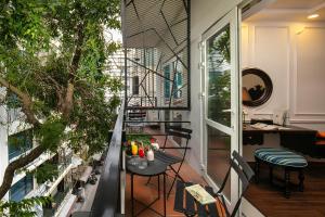 Apartment mit einem Balkon mit Tisch und Stühlen. in der Unterkunft San Boutique Hotel in Hanoi