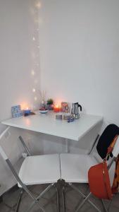 un tavolo bianco con una sedia e candele sopra di Fiu Relais a Napoli