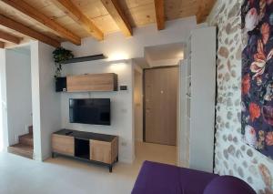 a living room with a flat screen tv on a wall at Sui Tetti di Valeggio - Holiday Apartment in Valeggio sul Mincio