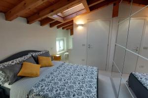 a bedroom with a bed in a room with wooden ceilings at Sui Tetti di Valeggio - Holiday Apartment in Valeggio sul Mincio