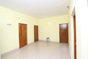 um quarto vazio com duas portas e paredes brancas em Flagship Nandan Residency em Bārang