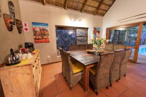a dining room with a wooden table and chairs at Sausage Tree Safari Camp in Balule Game Reserve