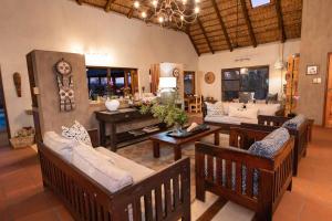a living room with couches and a piano at Sausage Tree Safari Camp in Balule Game Reserve