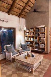 een woonkamer met een tafel en stoelen en boekenplanken bij Sausage Tree Safari Camp in Balule Game Reserve