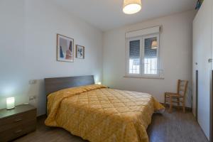 a bedroom with a bed and a chair and a window at Domus Bianca in San Giovanni di Sinis