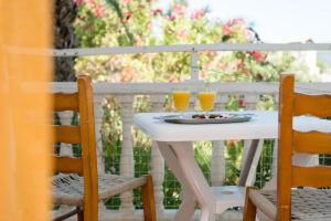 a white table with two glasses of orange juice at Kalofonos Studios in Laganas