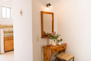 ein Badezimmer mit einem Spiegel und einem Holztisch in der Unterkunft Kalofonos Studios in Zakynthos