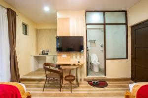 a hotel room with a bathroom with a toilet and a television at Hotel Atithi Satkar in Nagarkot