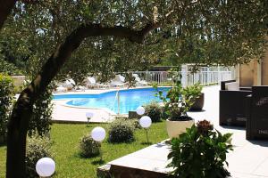 a swimming pool with white balloons in a yard at Apartments Grand Pinea in Čilipi