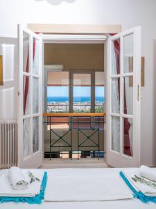 a bedroom with a view of the ocean seen through doors at Villa Verde in Malia